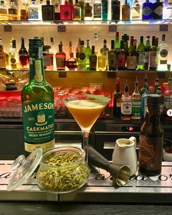 Interno bar con bottiglie di liquori e cocktail artigianale
