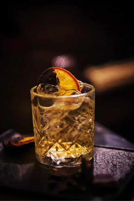 Cocktail su base chiara con decorazione di agrumi essiccati