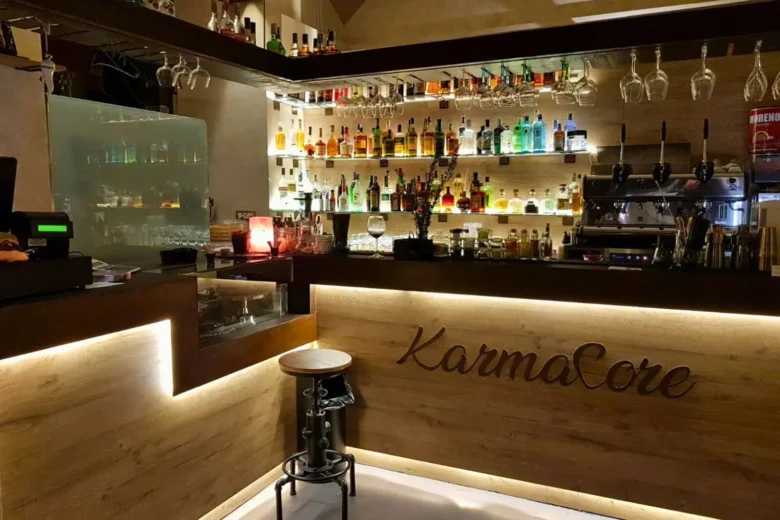 Interno del bistrot Karmacore a Napoli allestito per l’aperitivo serale, con bancone cocktail e luci calde