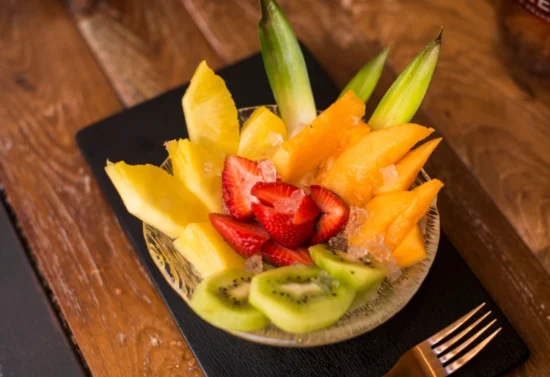Macedonia fresca con ananas, kiwi, fragole e melone servita con ghiaccio