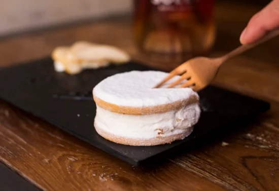 Dessert di ricotta e pera con biscotto sablé, servito su ardesia nera