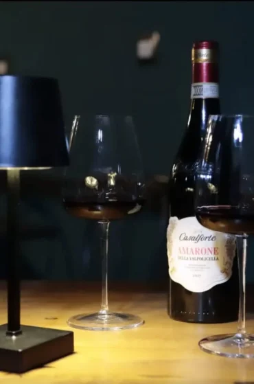 Calici di vino rosso e bottiglia di Amarone su tavolo elegante