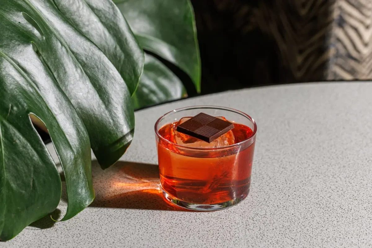 Cocktail con bitter servito con ghiaccio e cioccolato fondente