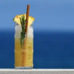 Cocktail tropicale con ghiaccio tritato, rosmarino e ananas