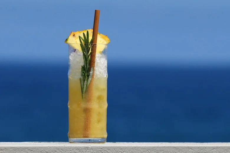 Cocktail tropicale con ghiaccio tritato, rosmarino e ananas
