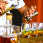 Preparazione di cocktail con rum e menta, bartender al lavoro.